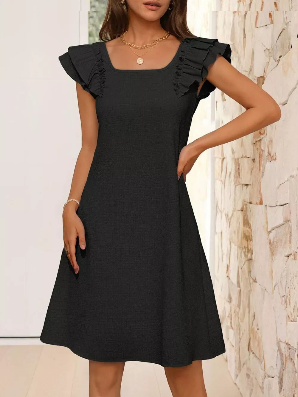 Black a-line dress with square neck and ruffled cap sleeves.