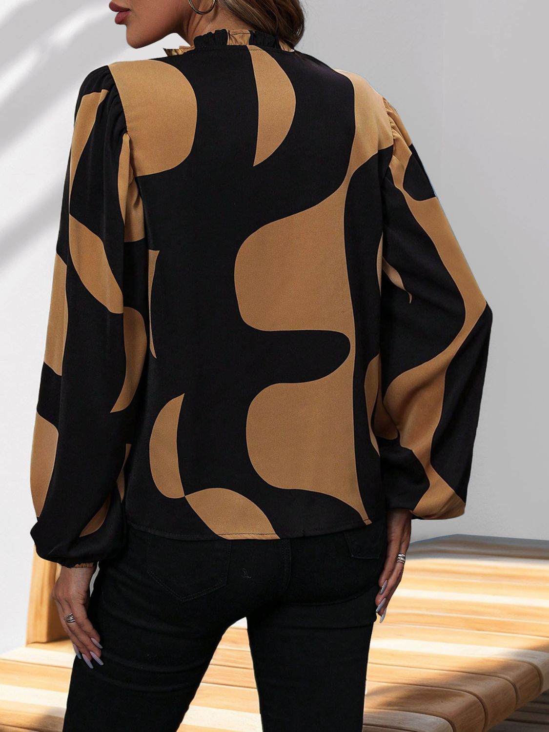 Black and tan geometric print blouse with voluminous sleeves and ruffled neckline.