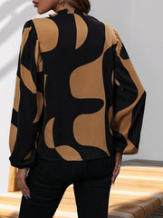 Black and tan geometric print blouse with voluminous sleeves and ruffled neckline.
