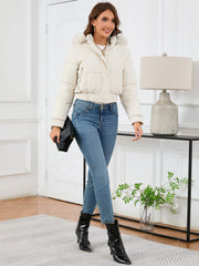 White faux fur trimmed puffer jacket with elastic cuffs and hem, worn with jeans.