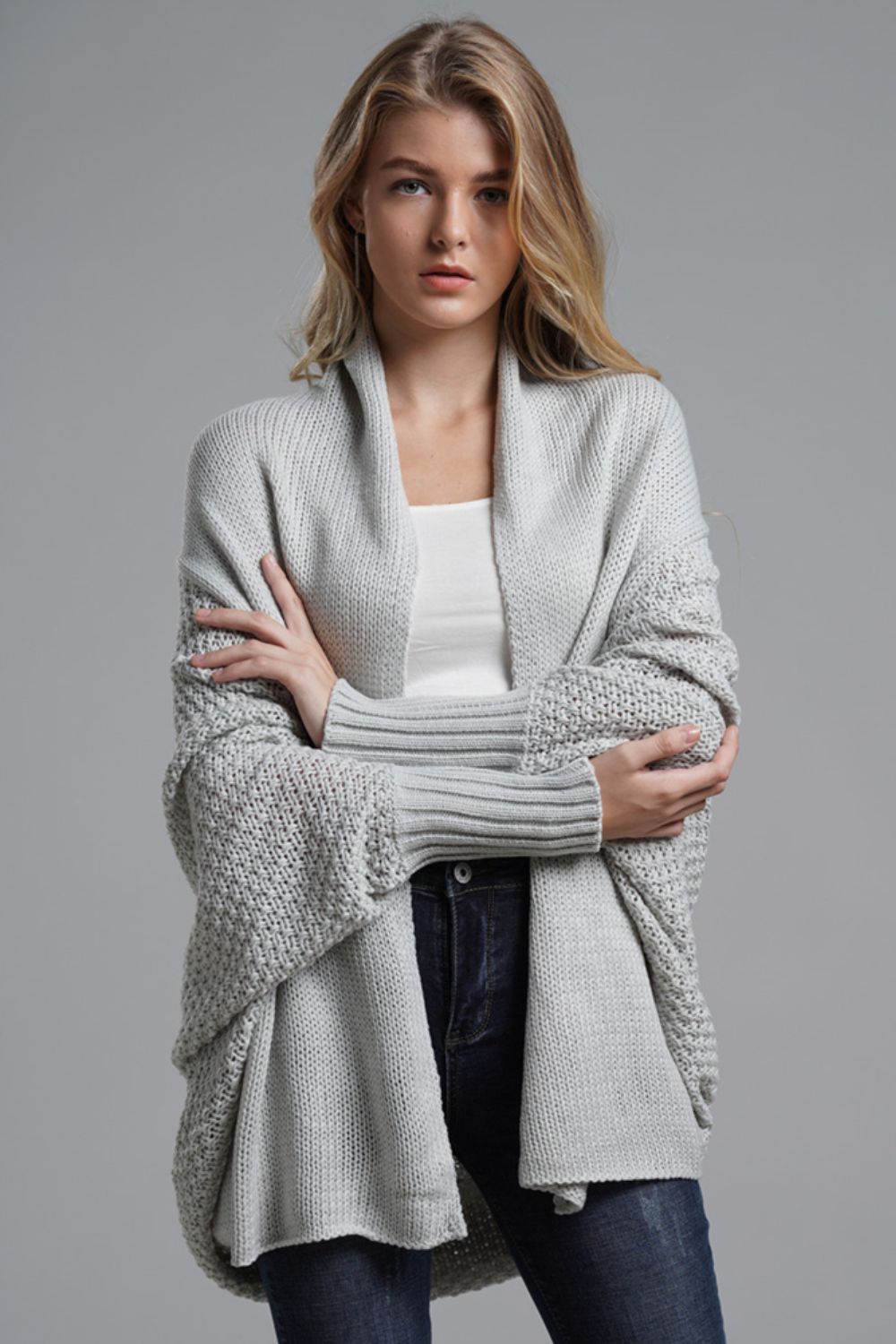 Gray knit batwing cardigan with drape front and textured sleeves.