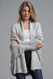 Gray knit batwing cardigan with drape front and textured sleeves.