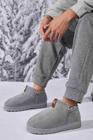 Gray suede shearling-lined house booties with a pull tab detail.