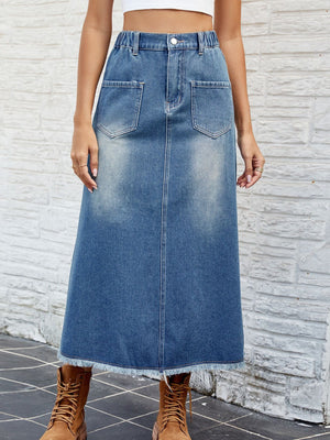 Faded blue denim midi skirt with frayed hem and front pockets.