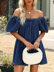 Off-shoulder denim mini dress with puff sleeves and tie-front detail in dark blue.