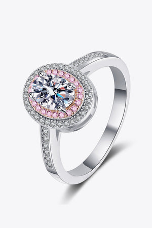 Silver ring with oval diamond, pink stone accents, and pave band.