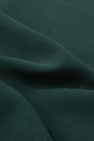 Dark green polyester midi dress fabric detail with soft folds.