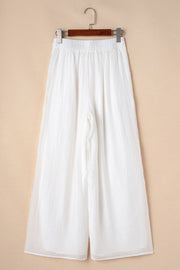 White pleated linen palazzo trousers with elastic waist
