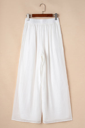 White pleated linen palazzo trousers with elastic waist