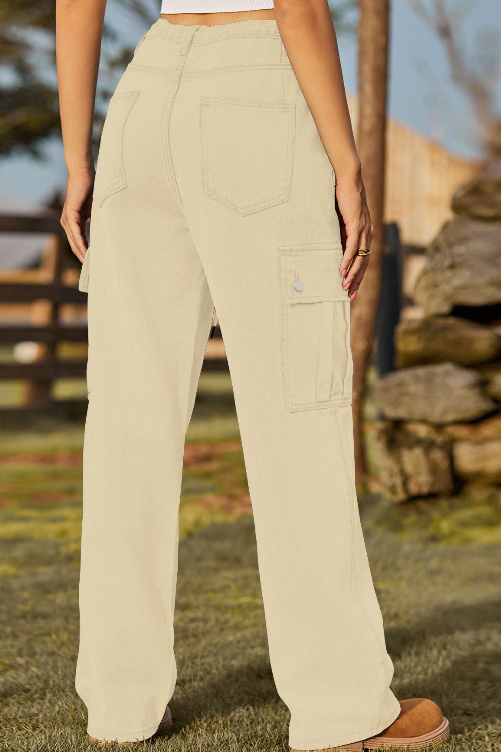 Tan denim cargo pants with utility pockets and a relaxed fit.