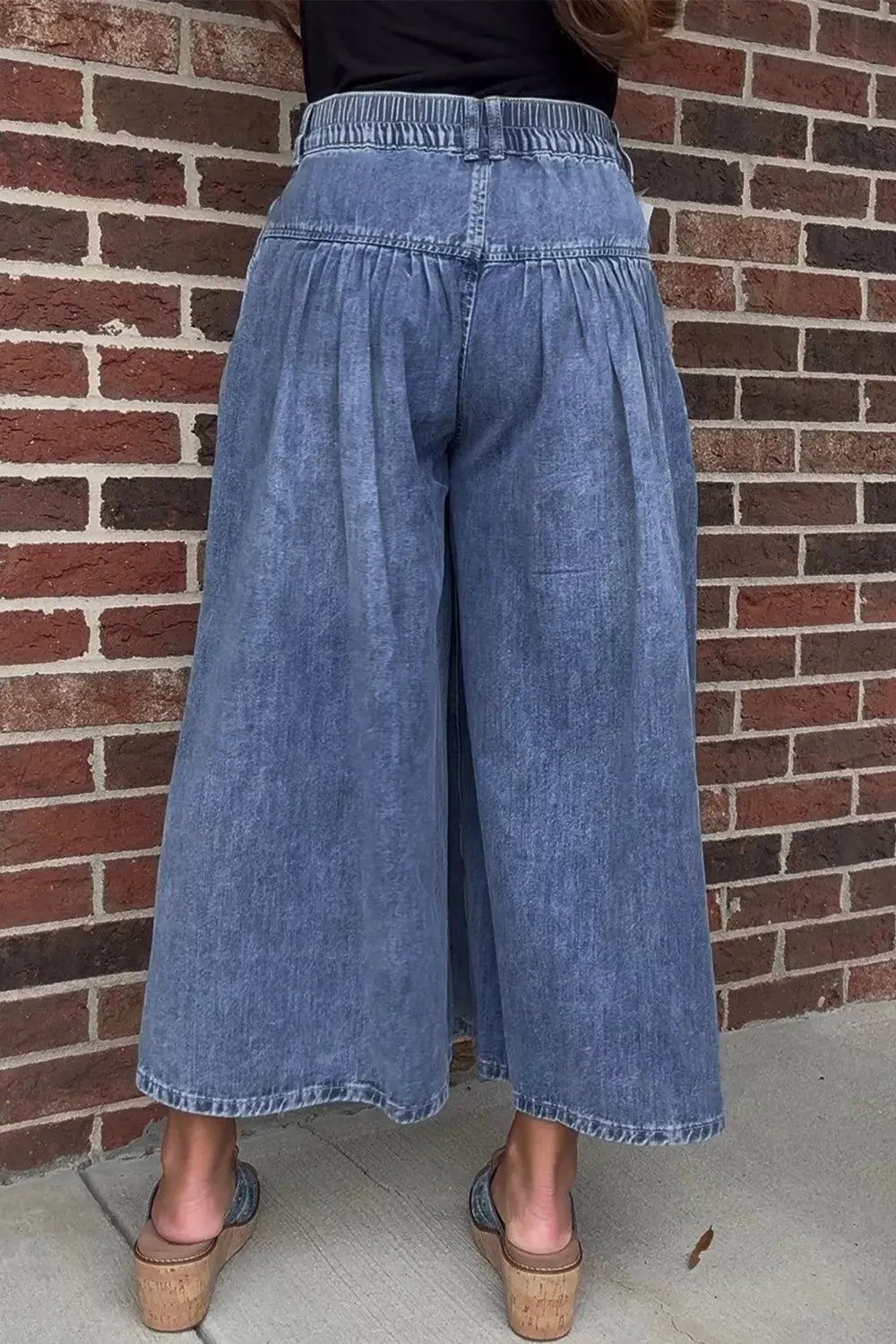 Maternity wide-leg jeans in blue denim with a high-waisted, elasticized back and pleated front.