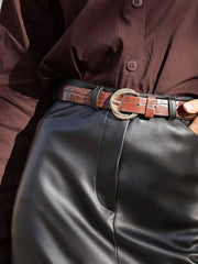 High-waisted black faux leather midi skirt with a brown croc-embossed belt.