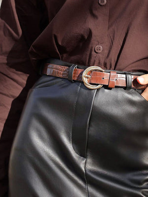 High-waisted black faux leather midi skirt with a brown croc-embossed belt.
