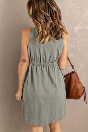 Gray button-down mini dress with gathered waistline and sleeveless cut.