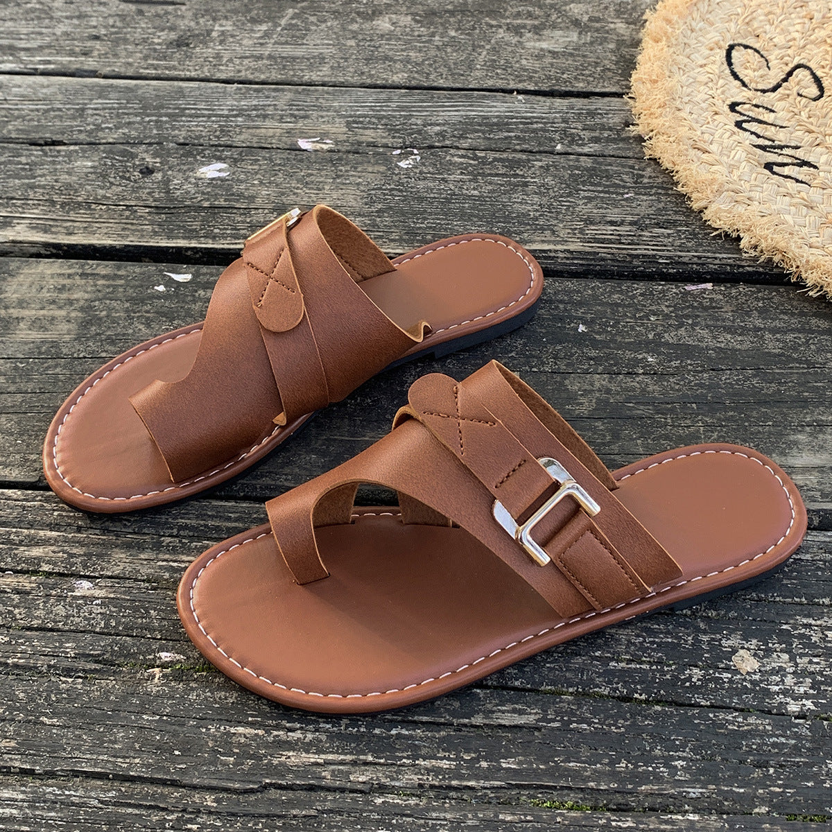Brown leather toe loop flat sandals with buckle detail.