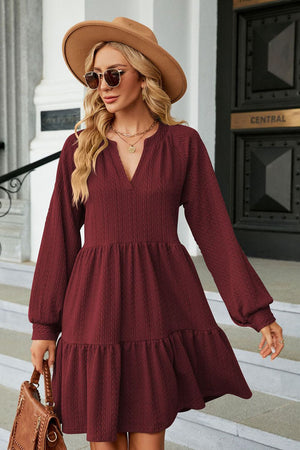 Burgundy textured babydoll mini dress with voluminous sleeves and tiered hem
