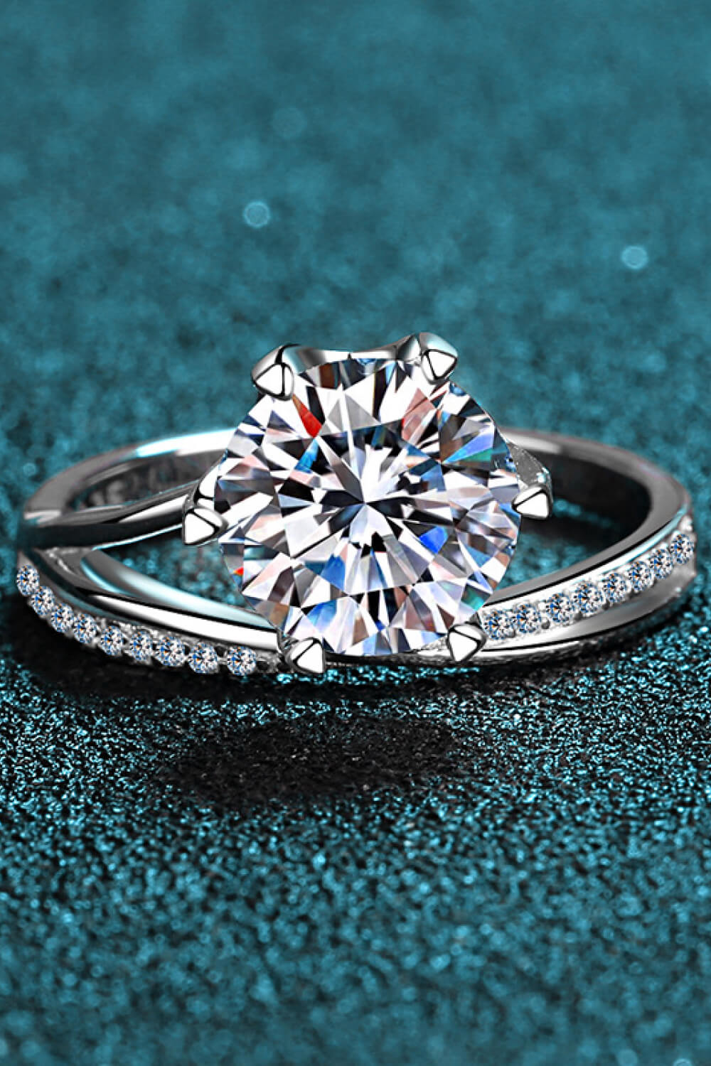 Silver bypass ring with large solitaire diamond and pavé band.
