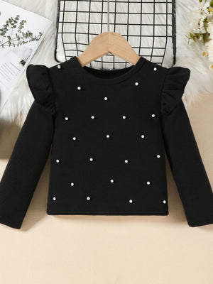 Toddler black ribbed long sleeve top with pearl embellishments and ruffled shoulders.