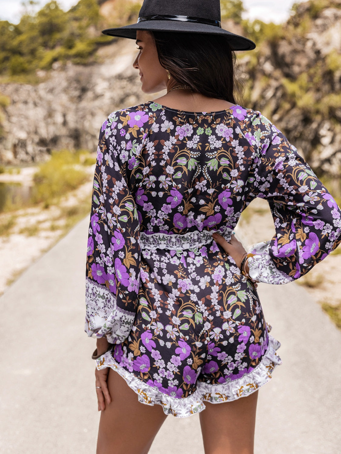 Floral print romper with blouson sleeves, cinched waist, and ruffled hem.