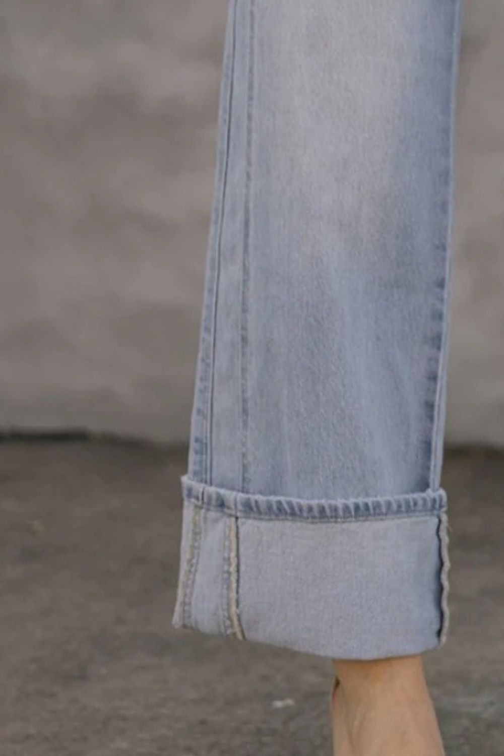 Light wash wide-leg denim jeans with contrast cuffs and visible stitching.