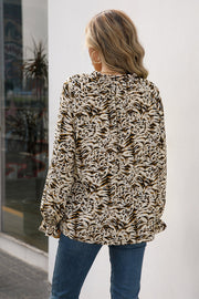 Animal print blouse with ruffle neckline and long sleeves in camel and dark blue.