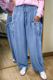Light blue denim maternity cargo jeans with drawstring waist and cinched ankles.