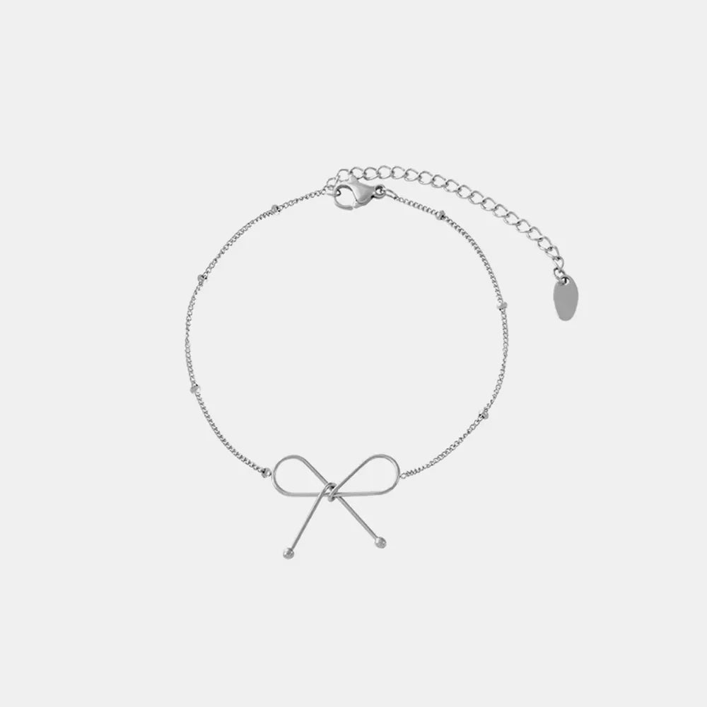 Silver delicate bow silhouette bracelet with beaded chain and adjustable clasp.
