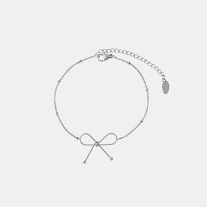 Silver delicate bow silhouette bracelet with beaded chain and adjustable clasp.