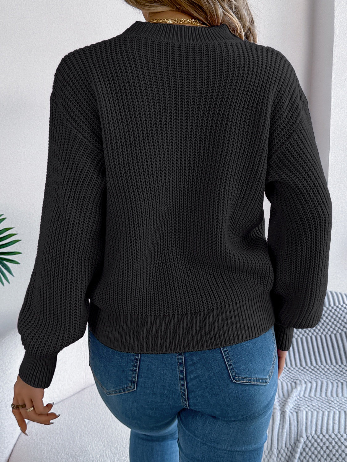 Black acrylic knit sweater with ribbed details and balloon sleeves.