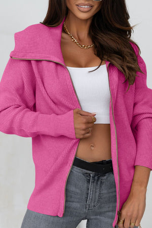Hot Pink ribbed knit cardigan with shawl collar and zip front, styled with a white crop top and grey jeans.