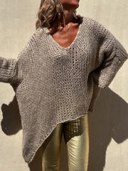 Camel open knit sweater with V-neck and asymmetric hem, featuring beaded trim detail.