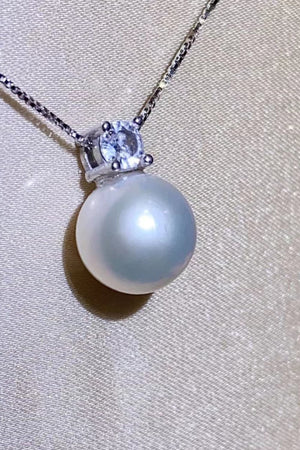 Solitaire pearl pendant necklace in silver with a clear stone accent on a delicate chain.
