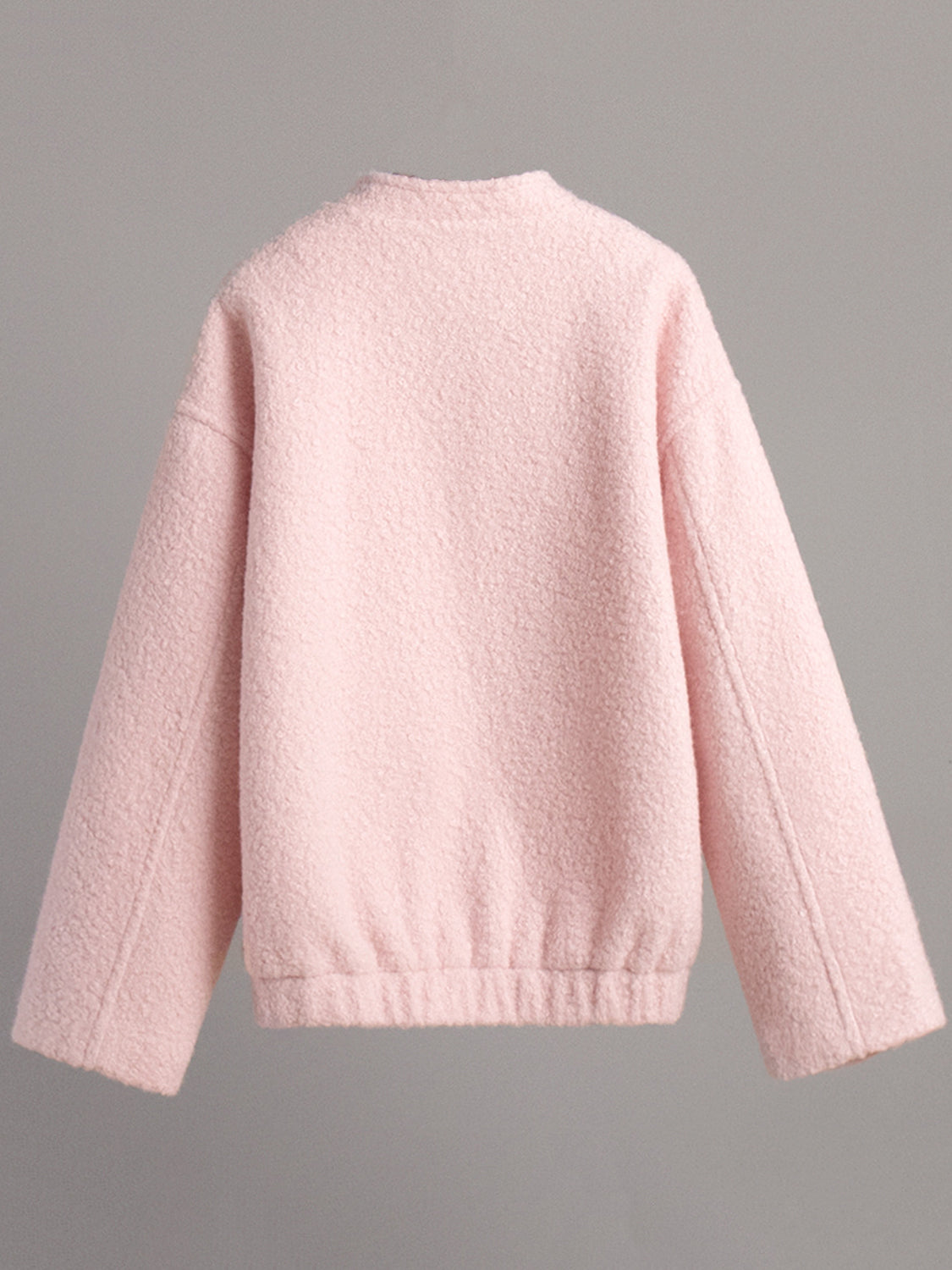 Textured blush pink bouclé bomber jacket with rounded neck and elasticated hem.