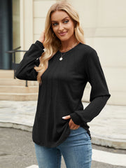 Black crew neck top with vertical seam detail and long sleeves