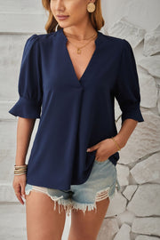 Dark blue puffed sleeve blouse with flared cuffs and V-neck.