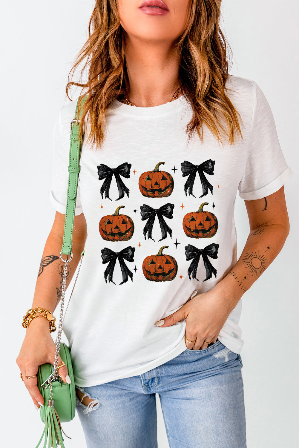 White graphic tee with a pattern of jack-o-lanterns and black bows.