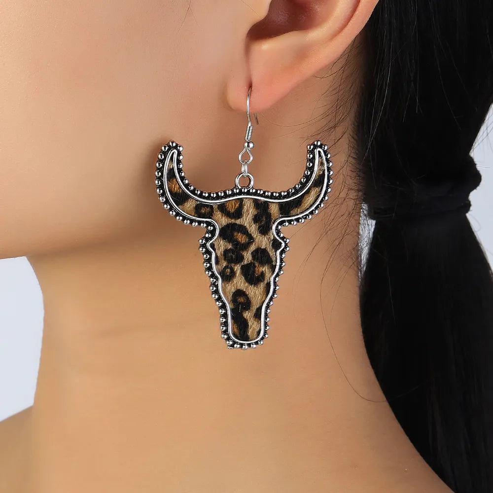 Leopard print bull head drop earrings with silver beaded trim.
