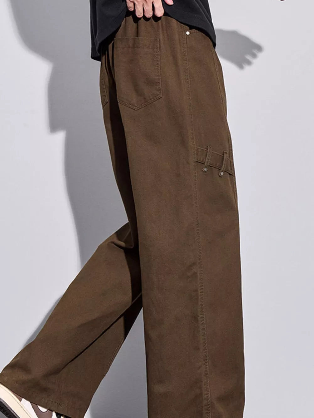 Brown loose-fit men's sweatpants with drawstring and side pocket detail.