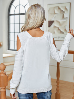White cable knit cold-shoulder sweater with button detail on sleeves.