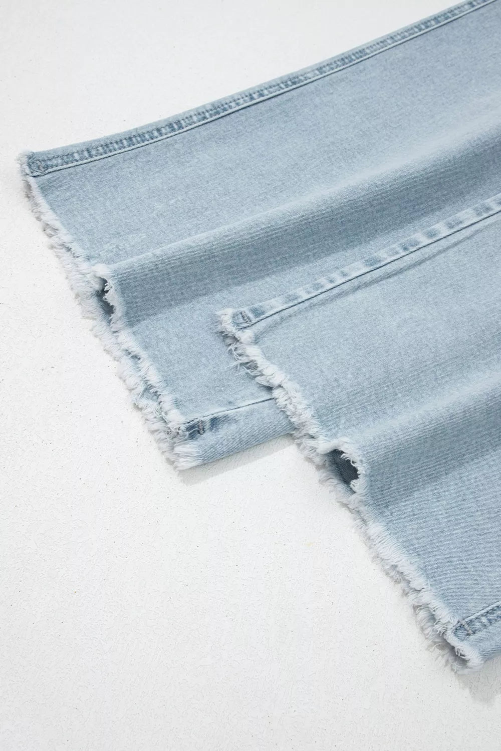 Light wash denim jeans with raw hem detail