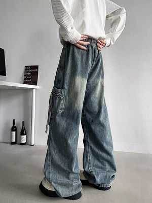Relaxed fit blue denim cargo jeans with drawstring waist and zip pocket detail.