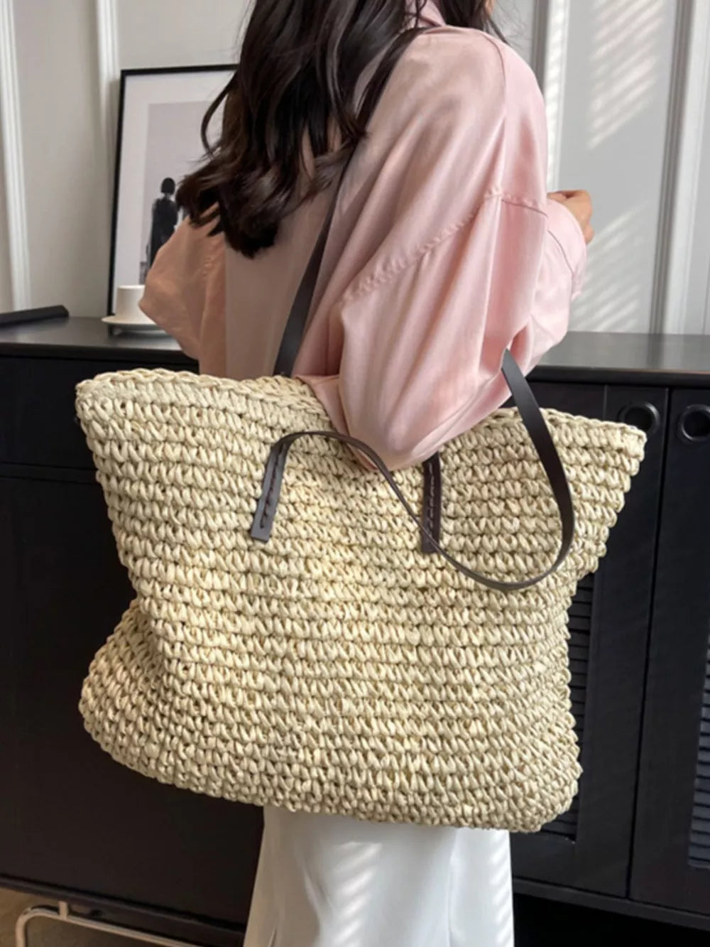 Natural woven straw shoulder bag in khaki with leather straps.