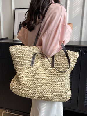Natural woven straw shoulder bag in khaki with leather straps.