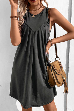 Dark gray sleeveless trapeze dress with pleated yoke detail.