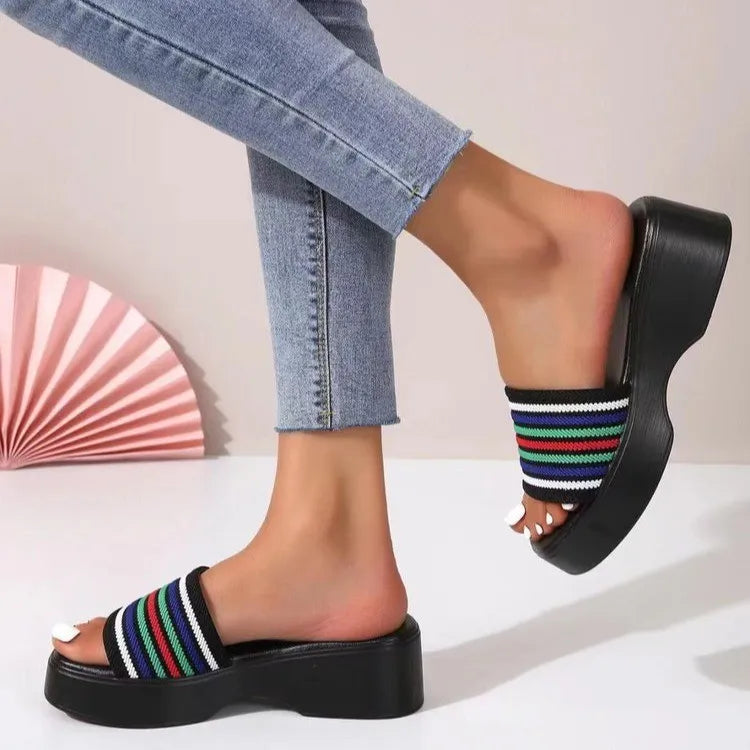 Platform knit slide sandals with black base and colorful striped band.