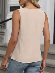 Sleeveless apricot tank top with a textured fabric and round neckline.
