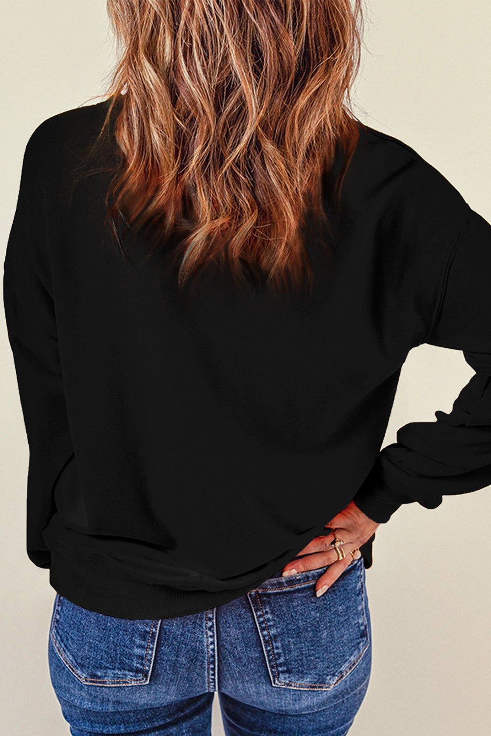 Black crewneck sweatshirt with graphic detail on back, casual fit.