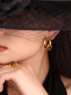 Gold sculptural hoop earrings and ring with tiger's eye stone accents.