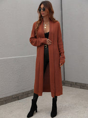 Brown textured knit maxi cardigan with open front and long sleeves, styled with a black top and boots.