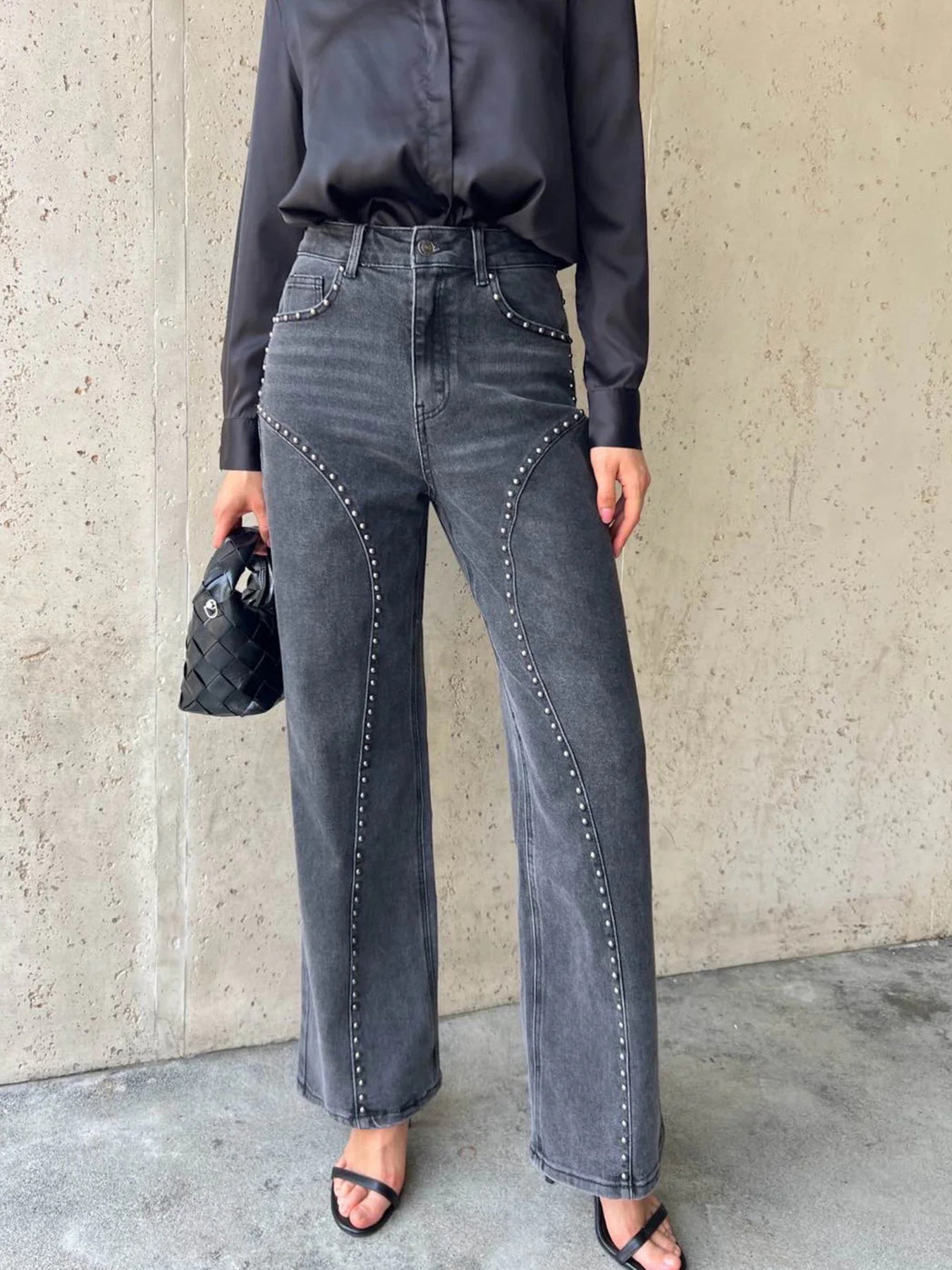 Dark gray studded high-waisted wide-leg jeans with button fly and flared hem.